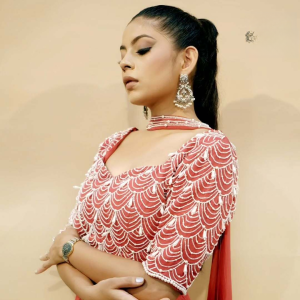 A Girl shines in a red pearl work lehenga set, highlighting her allure and elegance in a glamorous photoshoot.
